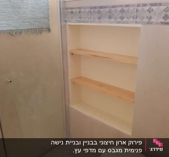 מדף עץ מובנה בקיר חדר אמבטיה